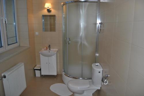 a bathroom with a shower and a toilet and a sink at Hotel Gościniec in Włocławek