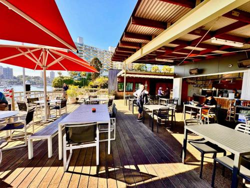 a restaurant with tables and chairs and a red umbrella at Harborside Studio Apt Walk to Shops Eateries in Sydney