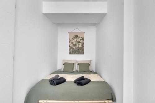 un lit dans une chambre blanche avec deux oreillers dans l'établissement Le Charles Roissard - Proche Gare, à Chambéry