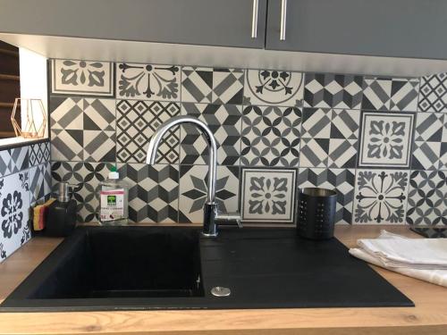 - une cuisine avec un évier et un mur en carrelage dans l'établissement Maison Harry Potter pour 6 personnes en centre ville, à Montauban