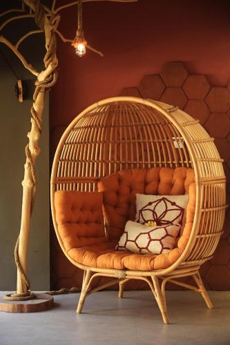 Una gran silla de ratán con forma de jaula de pájaros en una habitación. en Lasai Villas, en Gili Air