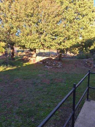 a fence in front of a park with a tree at Chez Loulou du Linas - Bugarach in Bugarach