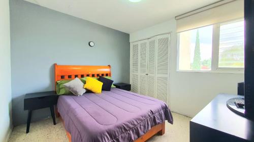 a bedroom with a purple bed with a window at Expo gdl y col americana in Guadalajara