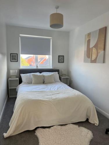 ein Schlafzimmer mit einem großen Bett mit einem großen Fenster in der Unterkunft Cosy 2 Bed Service Apartment Netflix Hideaway Family Couples Staycation Tredegar Park Celtic Manor ICC Wales in Lower Clapton