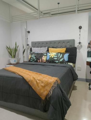 a bedroom with a large bed with a blanket on it at AGC Penthouse - Ground Floor Apartment in Zamboanga