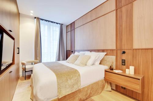 une chambre d'hôtel avec un grand lit et une chaise dans l'établissement Elegant apartment with AC -2BR-6P- le Marais, à Paris