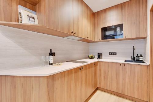 une cuisine avec des armoires en bois et un comptoir dans l'établissement Elegant apartment with AC -2BR-6P- le Marais, à Paris