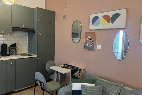 une cuisine avec des armoires vertes, une table et des chaises dans l'établissement Cosy air-conditioned studio in the heart of Nice, à Nice