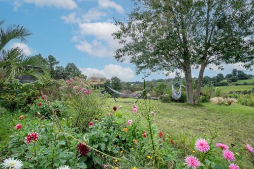 a garden with flowers and a hammock in the background at Keryanti in Plouégat-Moysan