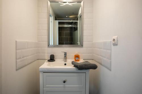 a white bathroom with a sink and a mirror at Keryanti in Plouégat-Moysan