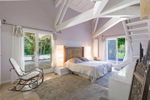 une chambre avec un lit, une chaise et des fenêtres dans l'établissement Souvenirs Intemporels, à Arles