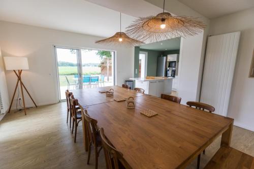 une salle à manger avec une grande table et des chaises en bois dans l'établissement Petite villa cassora, à Herm