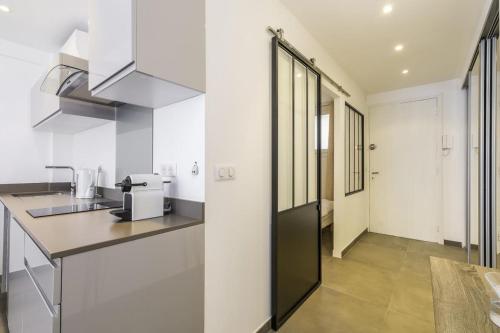 - une cuisine avec des murs blancs et un comptoir dans l'établissement Superbe T2 lumineux dans le centre CIO1899, à Cannes