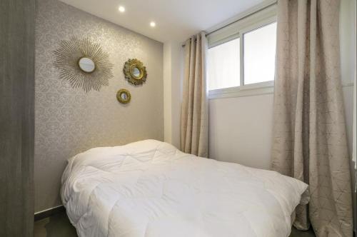 une chambre avec un lit blanc et une fenêtre dans l'établissement Superbe T2 lumineux dans le centre CIO1899, à Cannes