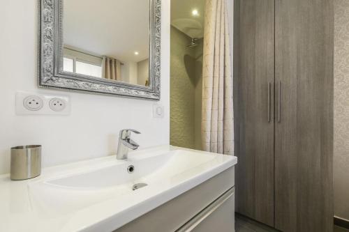 une salle de bain avec un lavabo blanc et un miroir dans l'établissement Superbe T2 lumineux dans le centre CIO1899, à Cannes