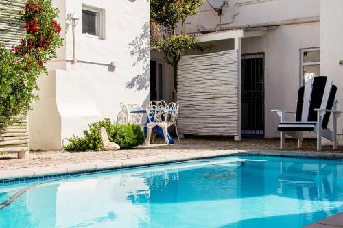 a small blue swimming pool in front of a house at Die Opstal house with Apartments in Paternoster