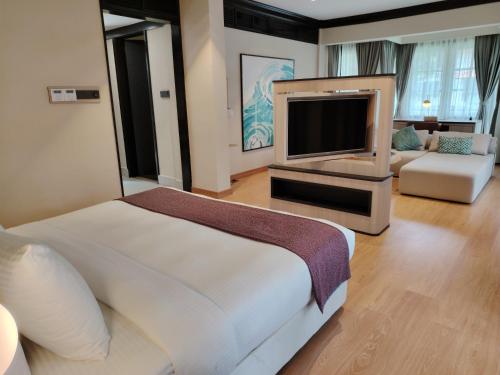 a bedroom with a bed and a flat screen tv at Sebana Cove Resort in Pengerang