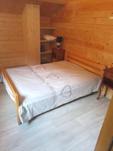 une chambre avec un lit dans une cabane en bois dans l'établissement Le Chalet des Comtois, à Cernans