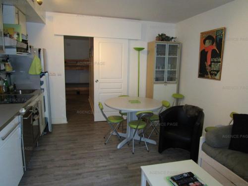 a living room with a table and a kitchen at Appartement Confortable pour 6 en Centre-Ville avec Balcon et Proximité Parking - FR-1-234-241 in Cauterets