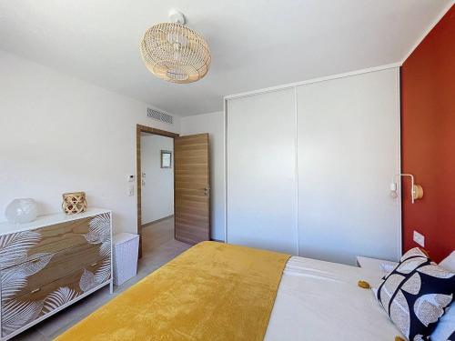 une chambre avec un lit avec une couverture jaune dessus dans l'établissement Appartement avec vue panoramique sur la mer, à Calvi