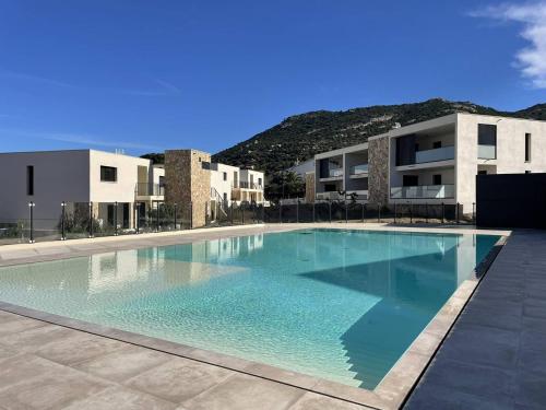 une grande piscine devant un immeuble dans l'établissement Appartement avec vue panoramique sur la mer, à Calvi