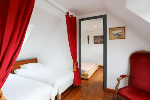 a bedroom with two beds and a mirror and a chair at Keryanti in Plouégat-Moysan