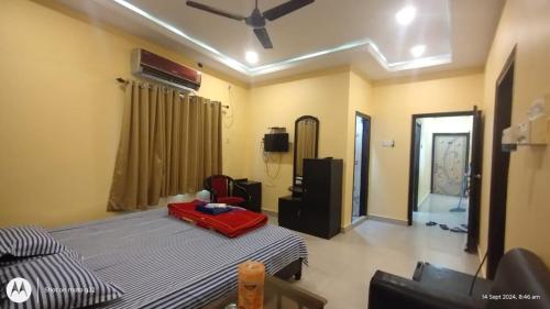 a living room with a bed and a tv and a room at Hotel Cosy Inn in Digha
