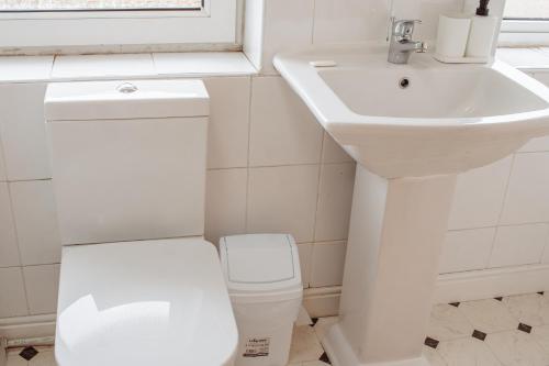 a white bathroom with a toilet and a sink at The Georgian House in Easingwold