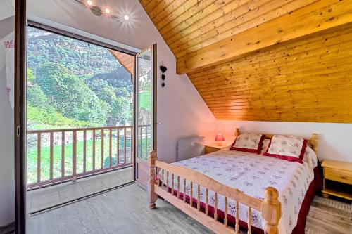 a bedroom with a bed and a large window at Bergerie route de Piau Engaly in Aragnouet