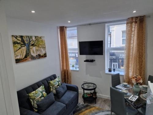 Una sala de estar con un sofá y un televisor. en 12 B Market Street, en Watford