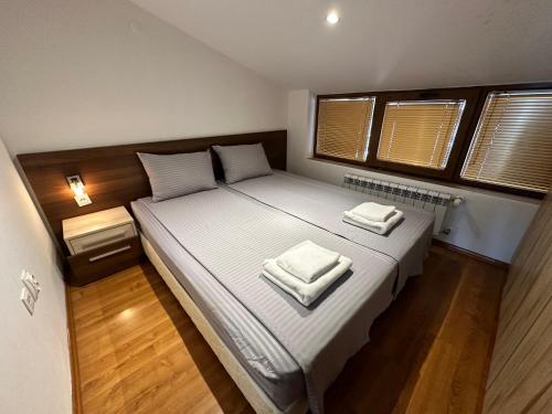 a bedroom with a large bed with two towels on it at Belvedere Holiday Club nice place in Bansko