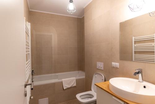 a bathroom with a sink and a toilet and a mirror at Apart B&V 706 Coresi - Balcony & Free Parking in Braşov