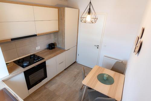 a small kitchen with a small table and a table and chairs at Apart B&V 706 Coresi - Balcony & Free Parking in Braşov