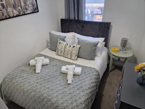 a bedroom with a bed with four rolled towels at 12 B Market Street in Watford