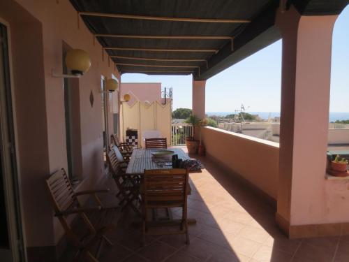 a patio with a table and chairs on a balcony at Casa Allegra Mondello in Palermo