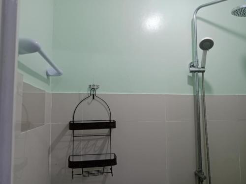 a shower with a towel rack in a bathroom at Pearls Z Apartelle in Boracay