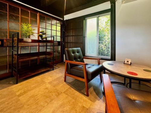 a living room with a table and a chair at 加美屋リゾート淡路 波枕うずしお-Kamiya Resort Awaji in Minamiawaji