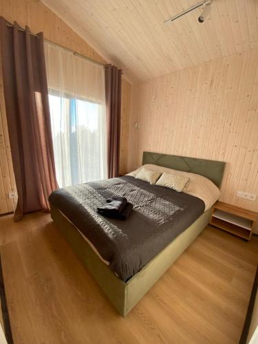 a bedroom with a large bed with a window at Красник Хілс in Krasnik