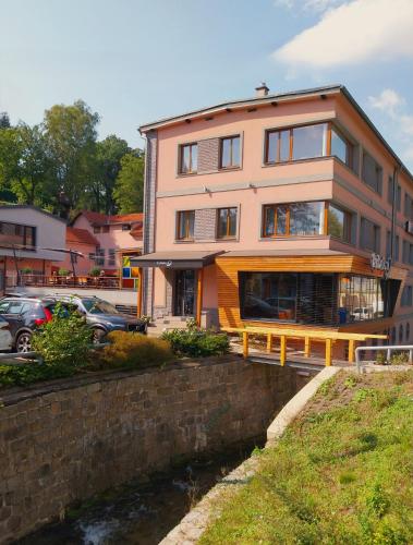 a large house with a river in front of it at Hotel Fabrica in Liberec