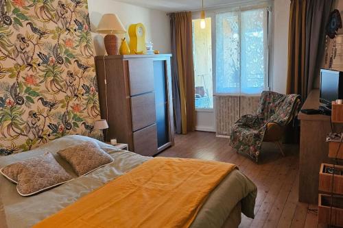 une chambre avec un lit et une chaise dedans dans l'établissement Maison de ville, à Louhans