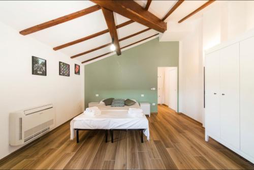 a bedroom with a bed in the middle of a room at Cicogna House in Villanova