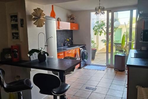 a kitchen with a table and some chairs in it at Maison de ville in Louhans