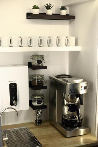 a kitchen with a coffee maker on a shelf at Central Backpackers in Oxford