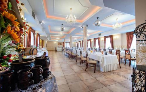a banquet hall with white tables and chairs and chandeliers at Hotel POD HERBEM -POKOJE OZONOWANE in Białystok