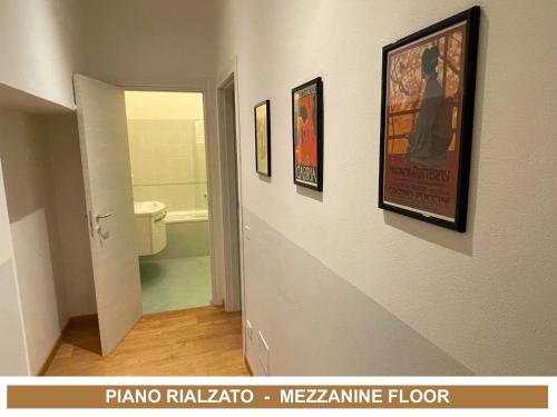 a bathroom with a toilet and some pictures on the wall at Lady Verona Residence in Verona