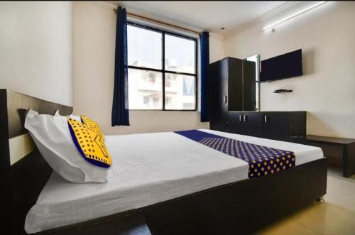 a bedroom with a large bed with a window at Hotel CROWN PLAZA SK in Rudrapur