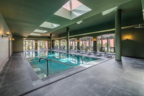 a large swimming pool with chairs in a building at Enotel Santo da Serra in Santo da Serra