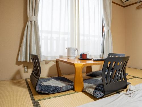 a dining room table with two chairs and a table at 手打ちそばの宿 石田屋 in Togari