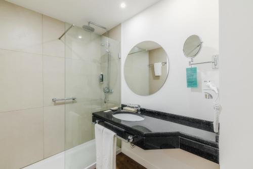a bathroom with a sink and a mirror at Enotel Santo da Serra in Santo da Serra