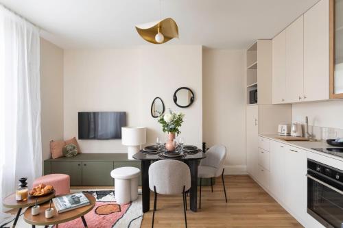 une cuisine et une salle à manger avec une table et des chaises dans l'établissement L'Albatre - Proche plage de Dinard, à Dinard